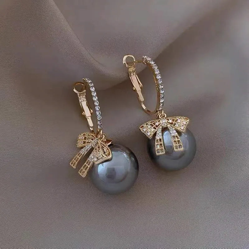 Pendientes de mujer con motivo de bola de Navidad, lazo y acentos de piedra